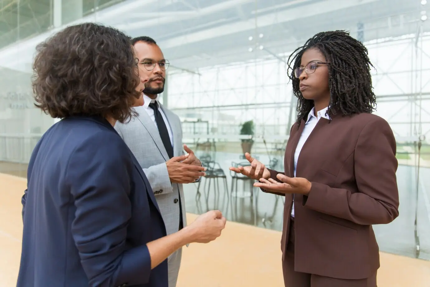 Разнорасовая бизнес-команда обсуждает проект на открытом воздухе.